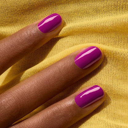 A hand with medium brown skin tone shows neatly manicured nails in Manucurist&
