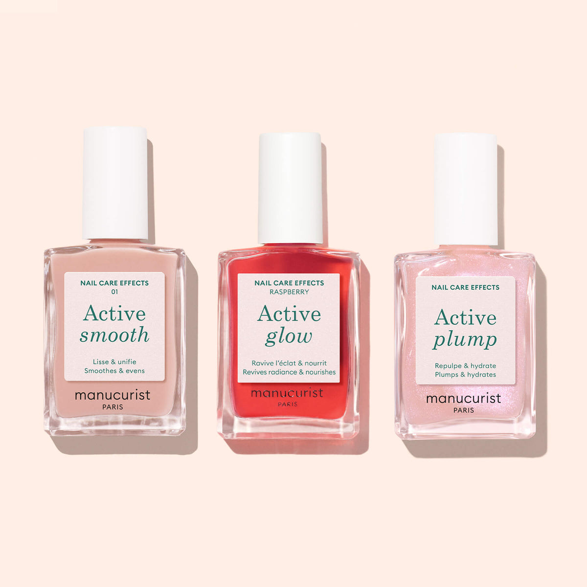 Trois flacons de soin des ongles d’origine végétale étiquetés Active™ Smooth 01 par Manucurist, contenant chacun un liquide CC Polish Treatment de couleur différente, présentés côte à côte sur un fond rose clair.
