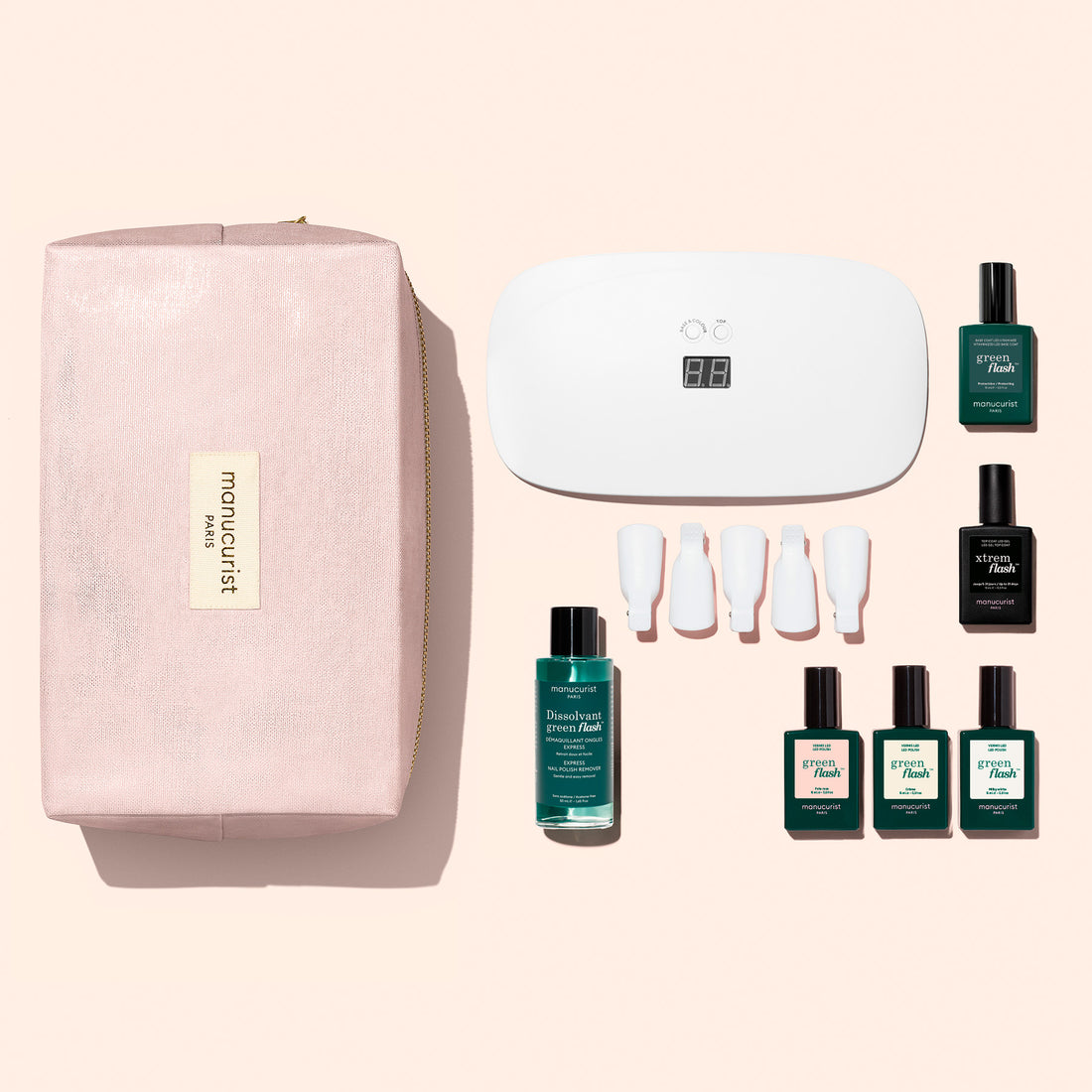 Starter Kit Green Flash™ Soap Nails de Manucurist comprenant une trousse de maquillage rose poudré, une lampe LED blanche, cinq clips en plastique pour les ongles, un flacon de dissolvant et quatre flacons de vernis longue tenue.