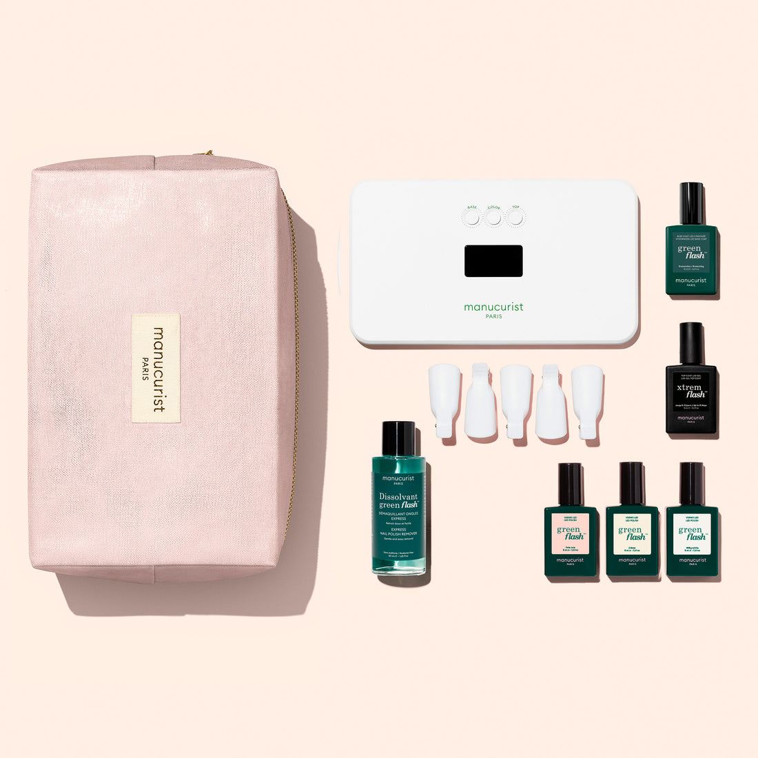 A Manucurist Starter Kit - Soap Nails LED Gel Polish including a white LED lamp, nail polish remover, five colored polishes, a top coat, and five finger clips, arranged next to a zippered makeup bag.