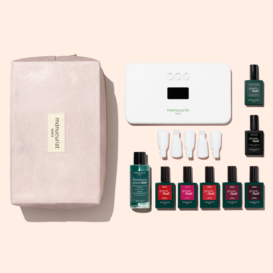 The Manucurist Super Starter Kit, arranged neatly on a light background, includes a pink pouch, UV lamp, nail polish remover, four polishes with white caps, plus two top/base coats—providing everything you need for an ultra-glossy manicure at home.