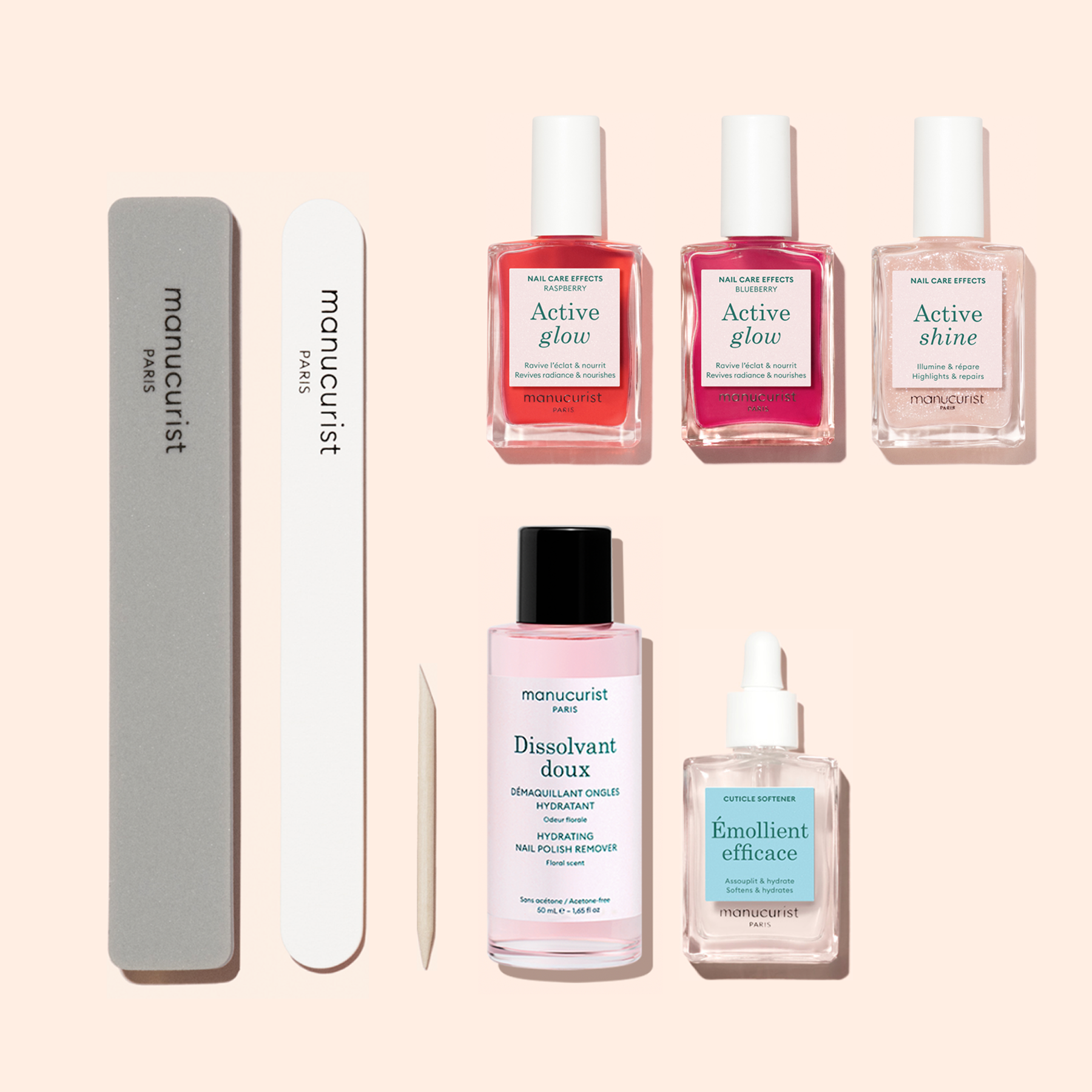The Manucurist Active Manicure Kit includes a gray and a white nail file, a wooden cuticle stick, three nail polish bottles, a pink bottle of remover, and a clear bottle of cuticle serum—each elegantly labeled "manucurist"—providing everything you need for the perfect at-home manicure.