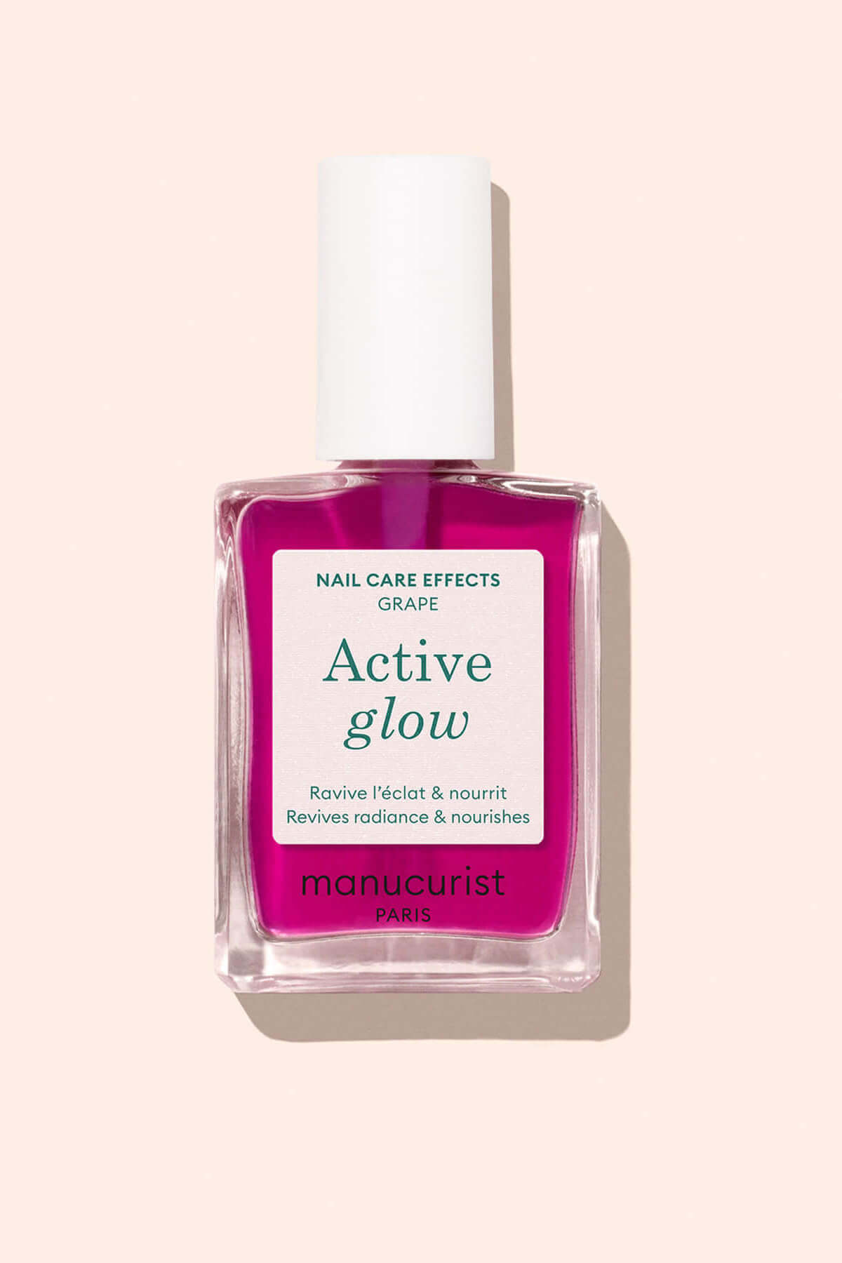 A bottle of Manucurist Active Glow nail care polish, with bright pink liquid and a white cap, is shown against a light beige background. The label mentions Nail Care Effects and Revives radiance  nourishes.