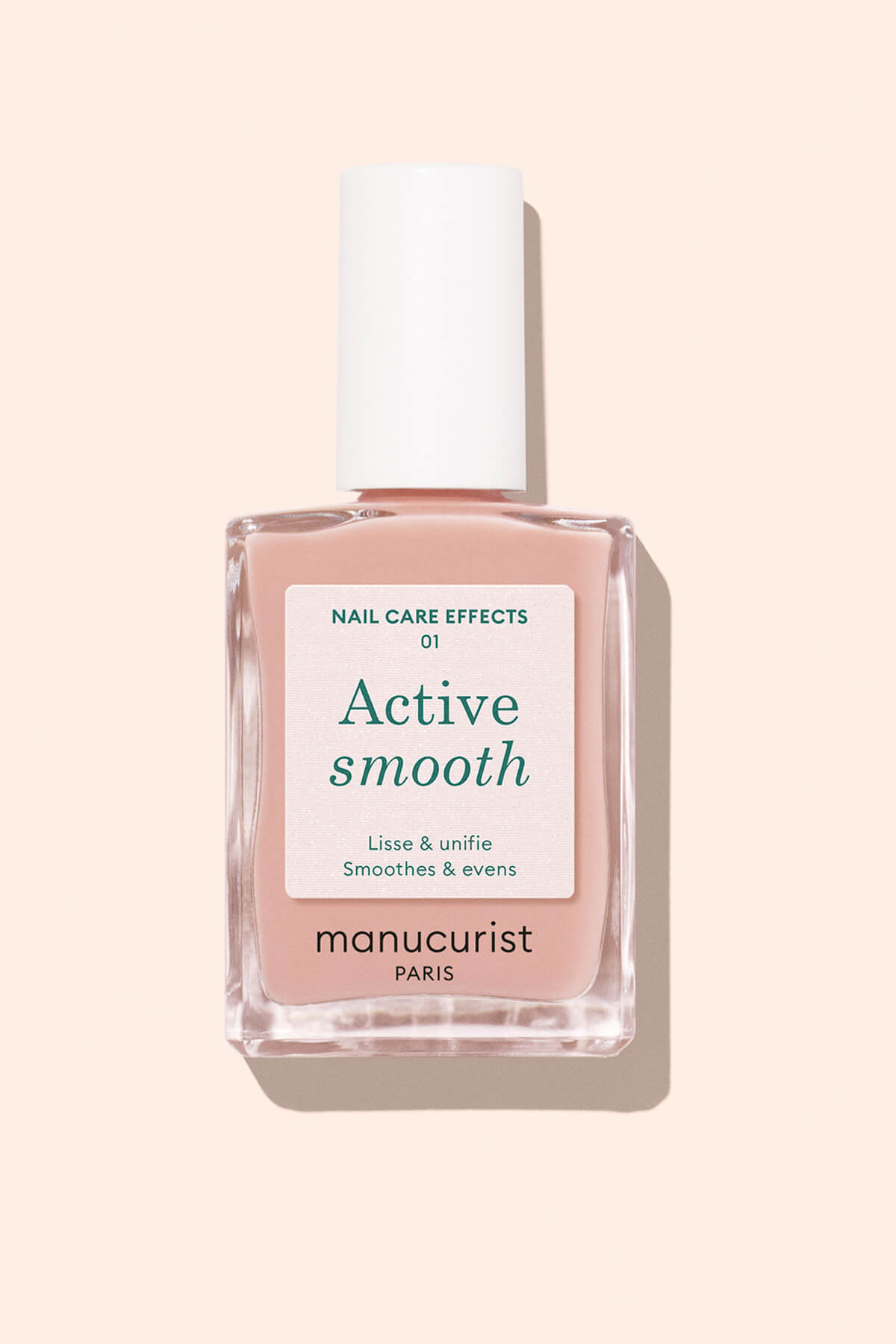 A bottle of Manucurist Paris nail polish labeled Active Smooth with a white cap, shown against a pale beige background. The label mentions nail care effects to smooth and even the nails.
