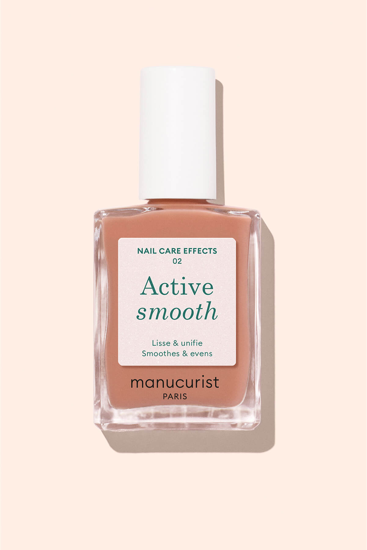 A bottle of Manucurist Paris Active Smooth nail polish with a white cap and a peach-toned label, photographed against a pale peach background.