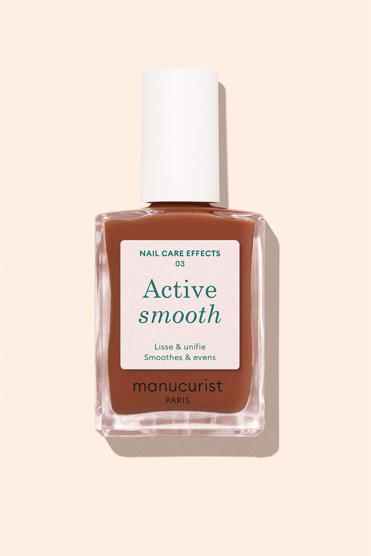A bottle of Manucurist Paris Active Smooth nail care polish, featuring a brown liquid, a white rectangular cap, and a white label with green and black text on a light beige background.
