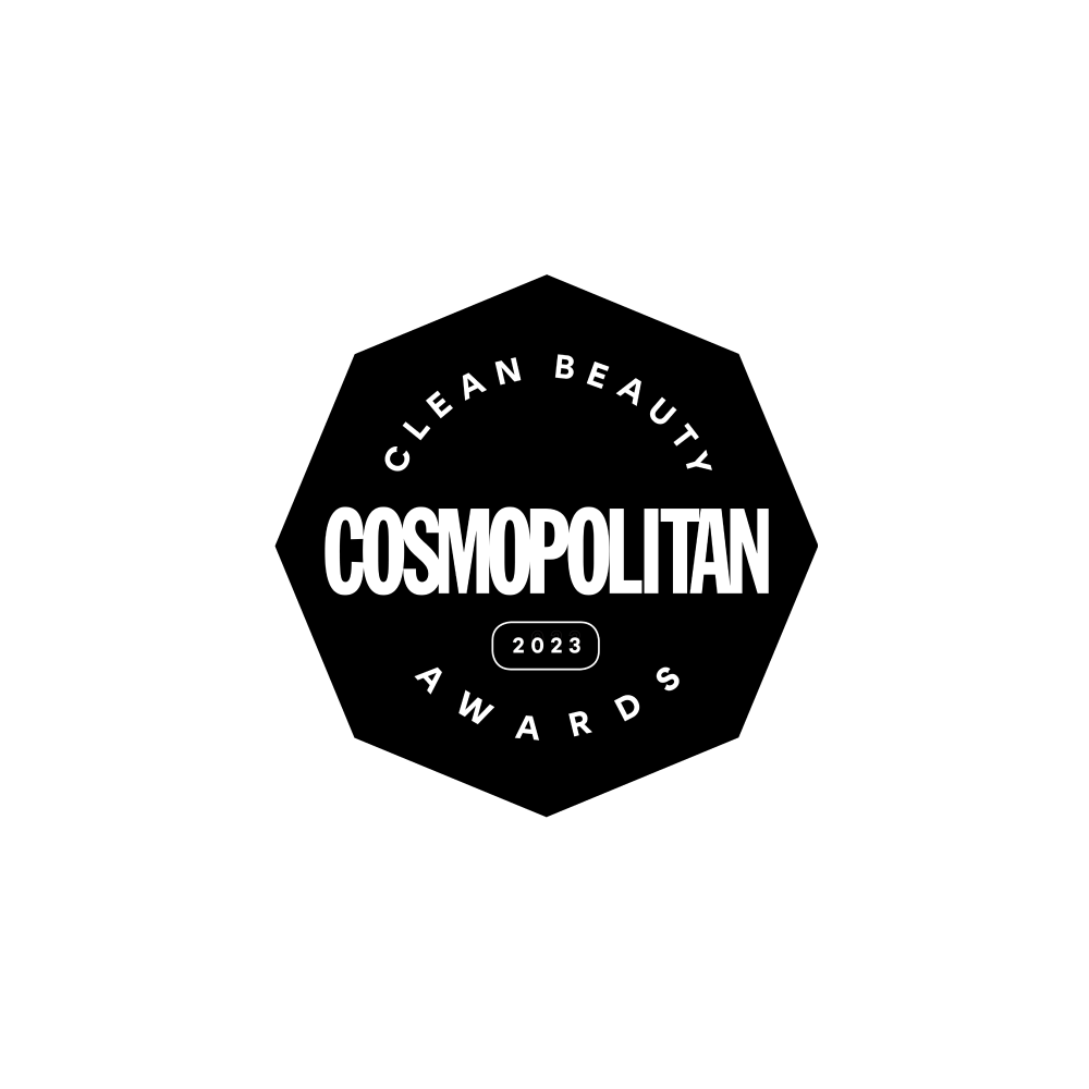 Un badge hexagonal noir avec un texte blanc indique Clean Beauty Awards Cosmopolitan 2023 sur un fond gris clair.