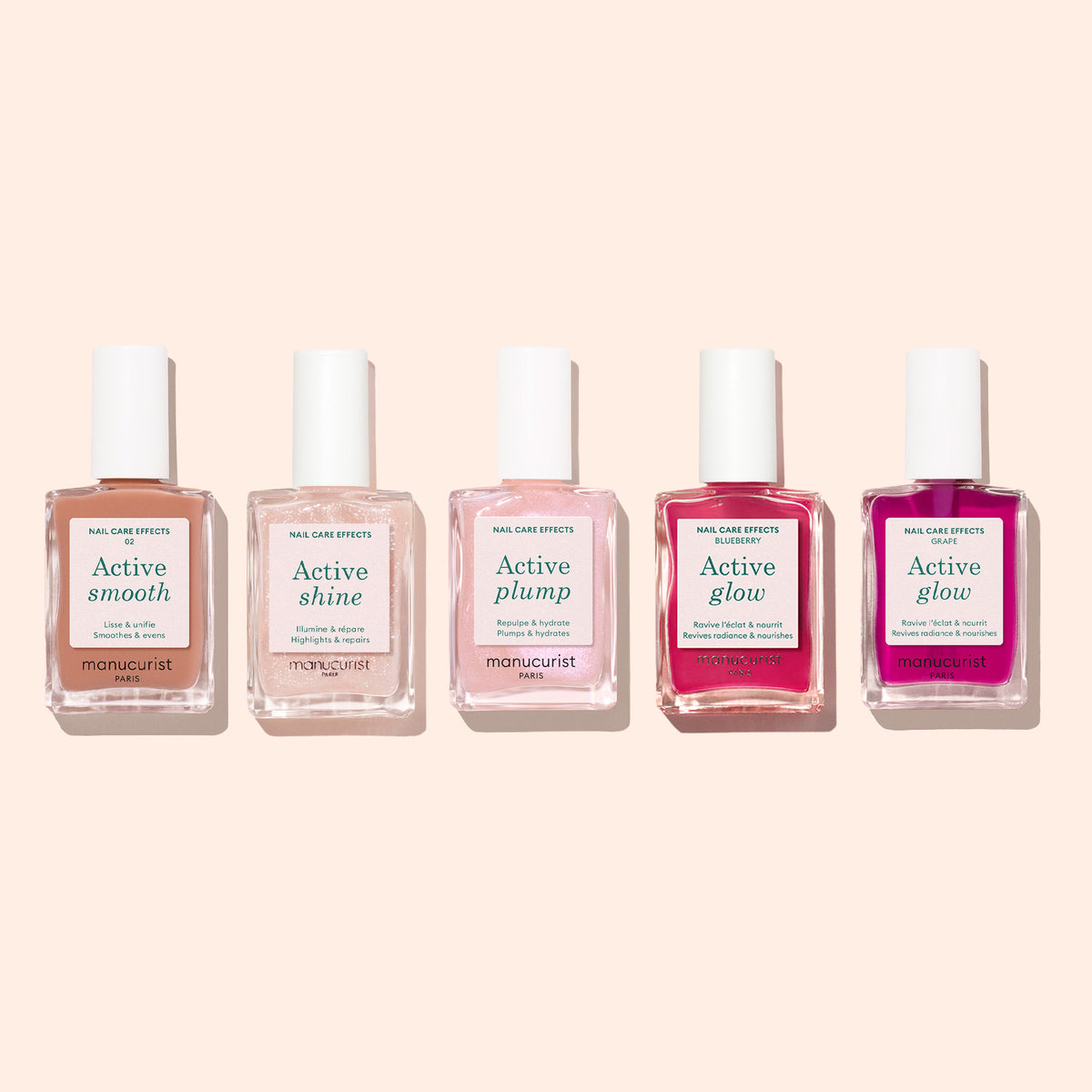 Cinq bouteilles de soin ongles Manucurist sont disposées en rang sur fond beige clair. Chaque bouteille, issue de la collection innovante Active™ de Manucurist, indique un effet différent : Active™ Smooth 02, Active Shine, Active Plump, et deux bouteilles d&