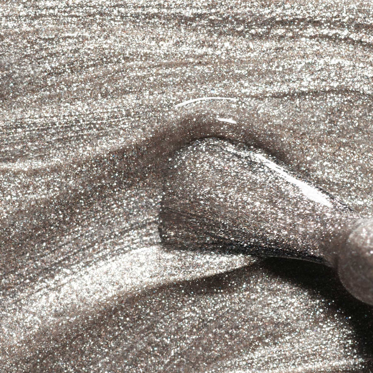 Gros plan sur un pinceau de vernis à ongles appliquant le vernis gel Green Flash™ Disco de Manucurist, révélant une surface lisse et réfléchissante avec de fines paillettes opaques et un éclat éblouissant.