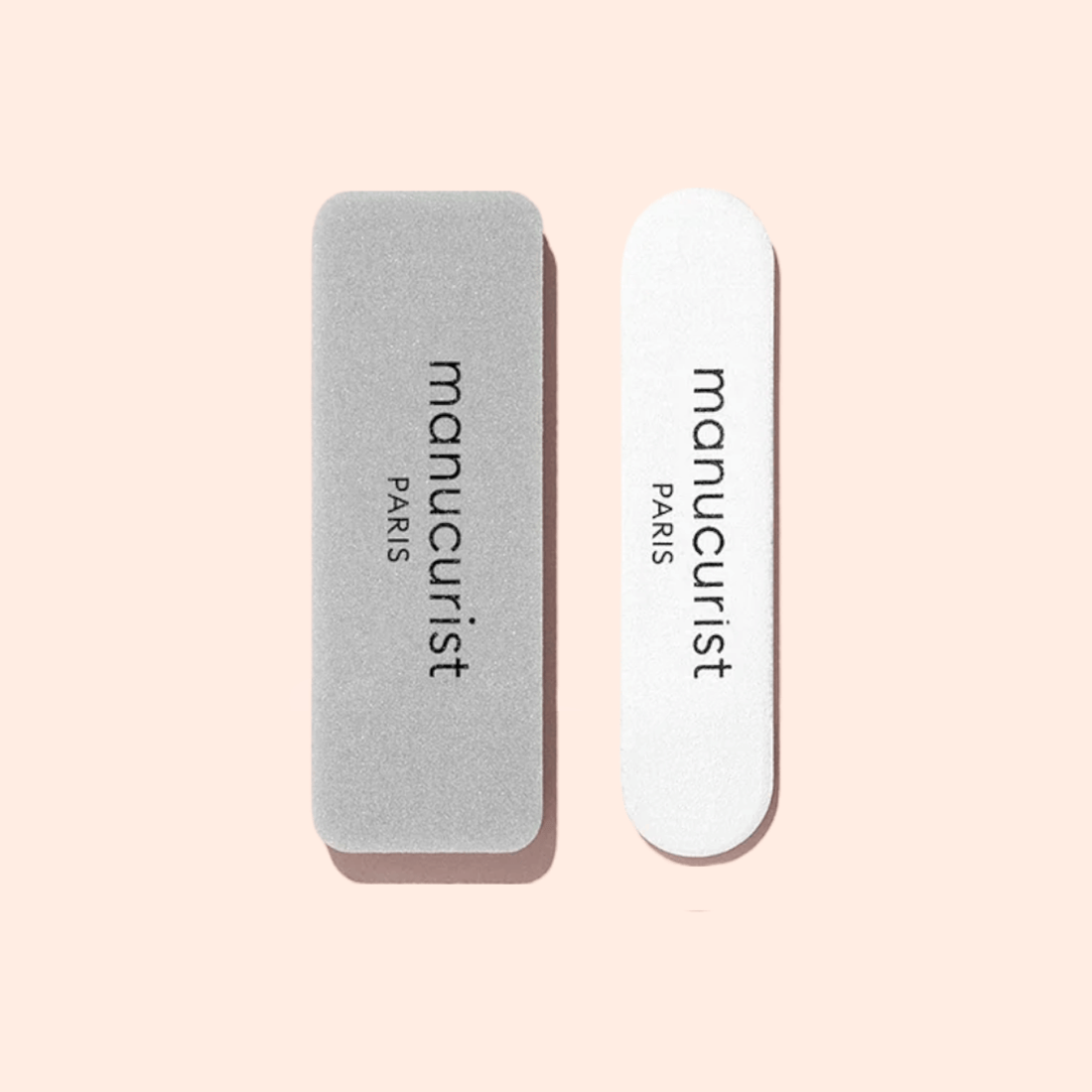 The Manucurist-test Mini Nail File Duo - Free features two rectangular nail buffers, one gray and one white, displayed side by side on a light pink background.