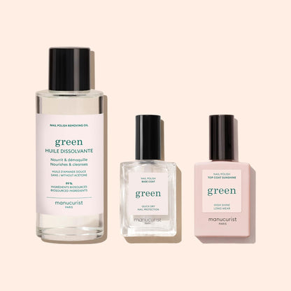 Three manicure products on a beige background: Manucurist’s Nail Polish Removing Oil, a square plant-based base coat, and a rectangular high-shine top coat—all labeled green by Manucurist Paris.