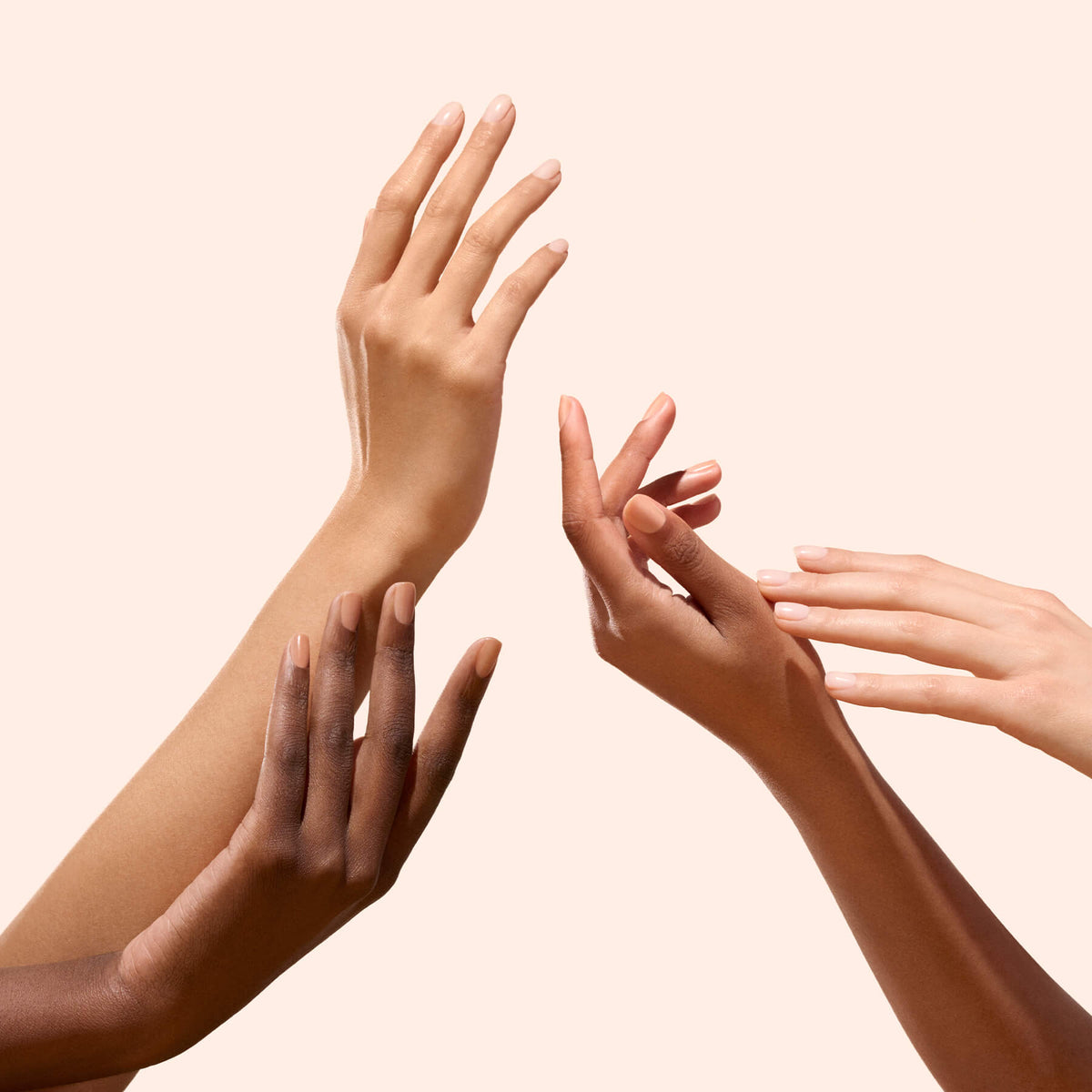 Quatre mains aux carnations variées présentent les vernis Customizable Active™ en pack de 5 de Manucurist sur un fond neutre, célébrant la diversité, l’unité et le soin des ongles personnalisé.
