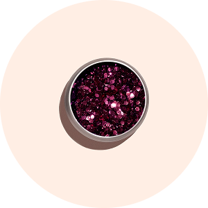 Un petit contenant rond rempli de paillettes rose foncé brillantes, vu de dessus, posé sur un fond pêche clair.