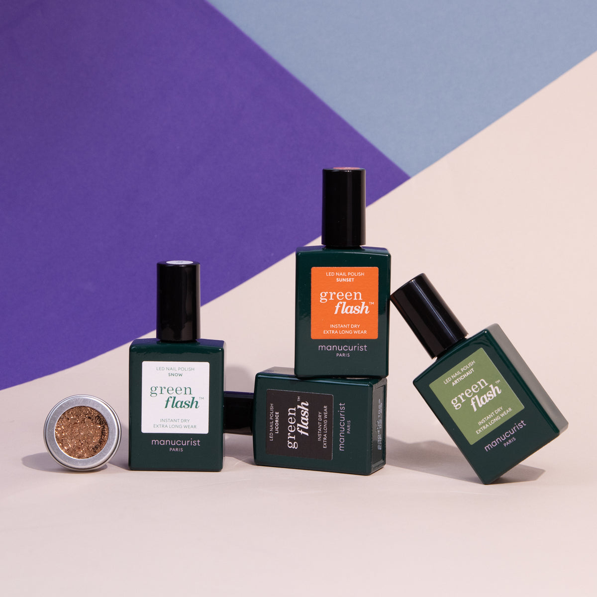 Quatre flacons de vernis gel Pumpkin Patch de Manucurist sont disposés avec un petit pot ouvert de paillettes cuivrées, le tout sur un fond géométrique violet, bleu et crème.