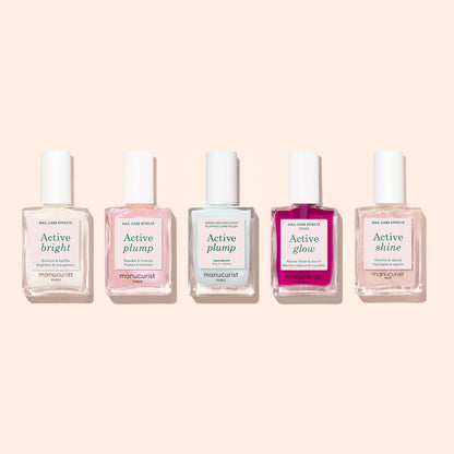 Five bottles of Manucurist nail care treatments, including Active Plump Aqua Glazed for hydrated nails and a pearly finish, are arranged in a row. Each is labeled with effects: Active bright, plump (twice), glow, and shine.