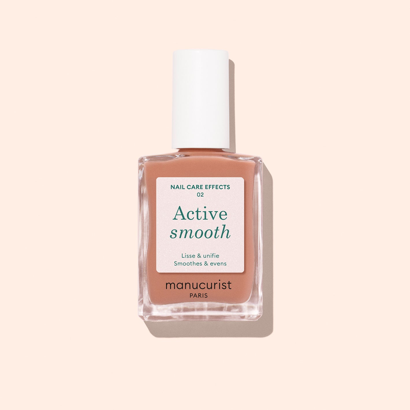 A bottle of Manucurist Active Smooth 02 with a white cap sits on a light peach background. The label highlights the polish's nail-perfecting, smoothing, and evening effects for advanced nail care.