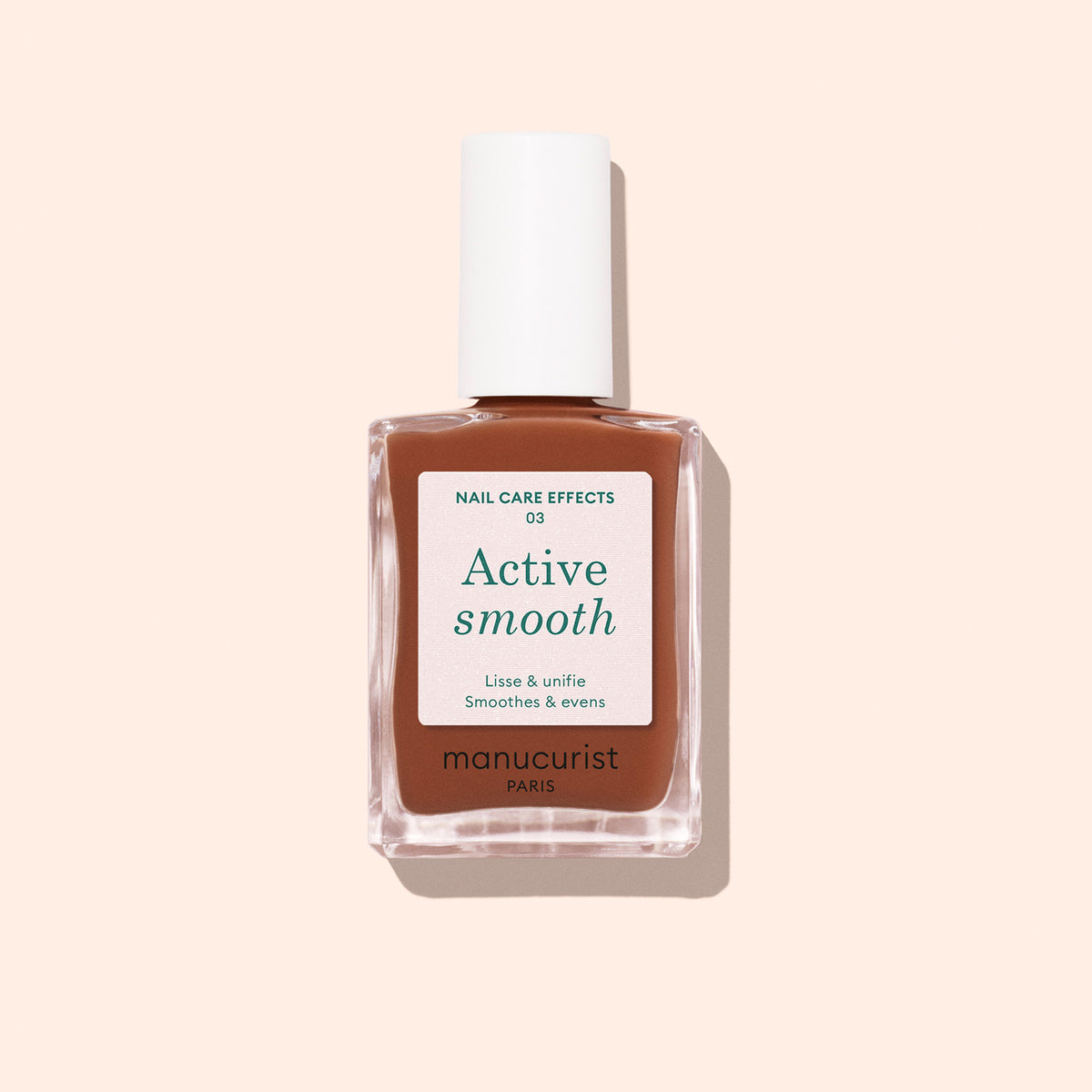 Un flacon de soin pour ongles Active Smooth 03 de Manucurist avec un bouchon blanc, un flacon en verre transparent et une étiquette beige-brun, présenté sur un fond rose pâle.