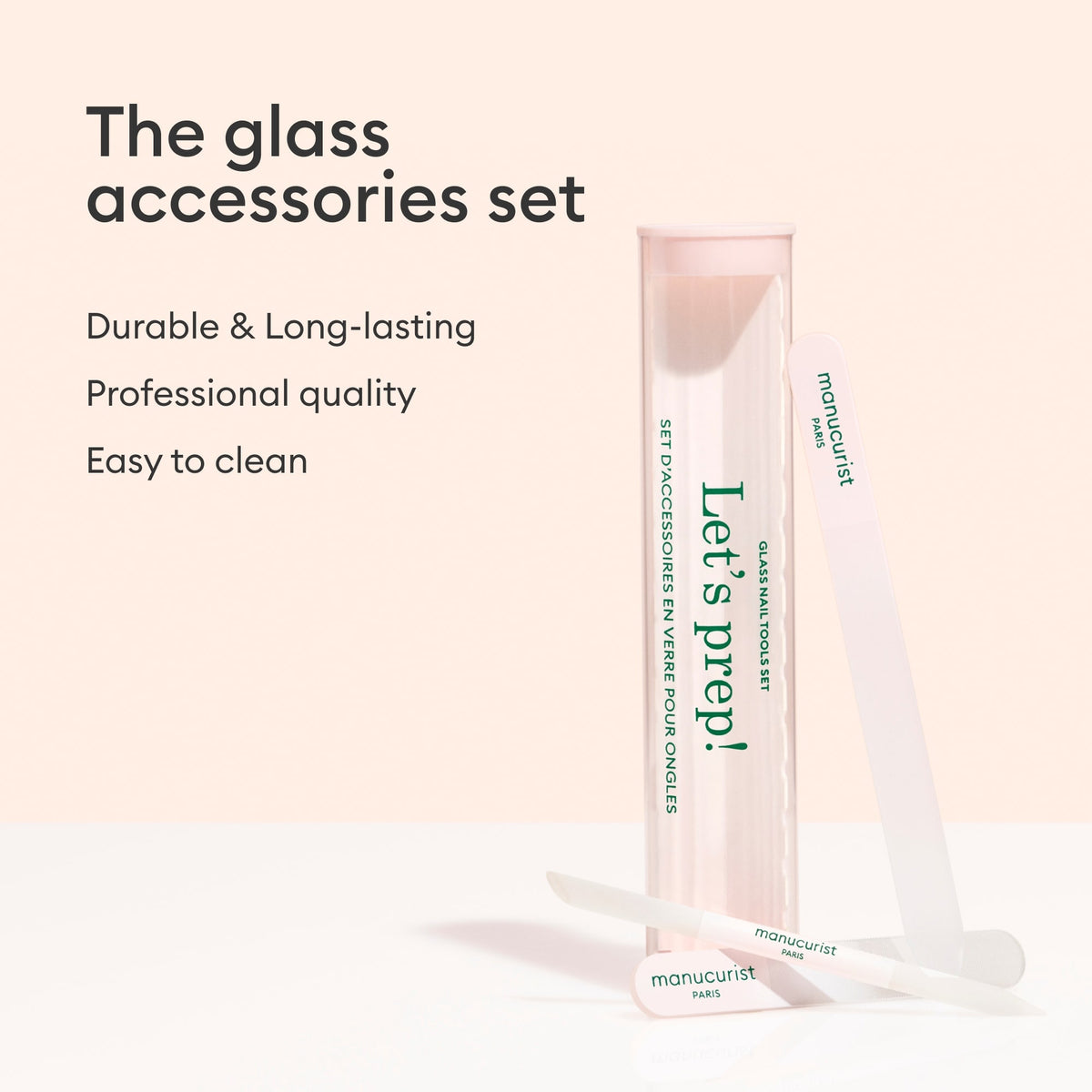 A pink and clear Manucurist-us case labeled "Lets prep!" stands upright beside a glass nail file and cuticle pusher. Text: Glass nail accessory trio—durable, long-lasting, professional quality, easy to clean.