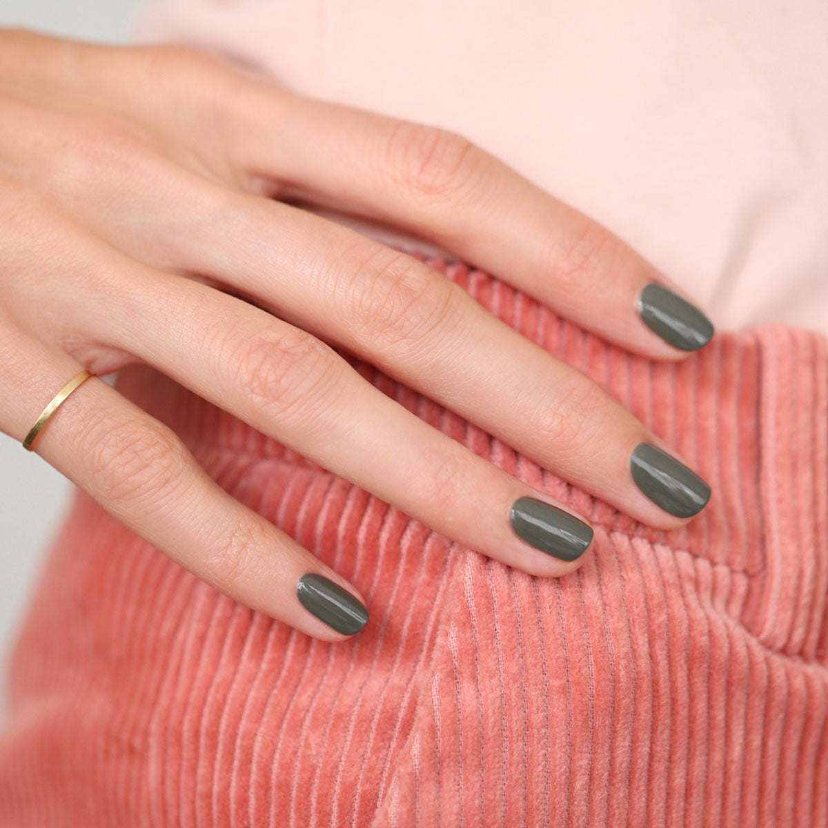 A hand with short, neat nails painted in Manucurist&