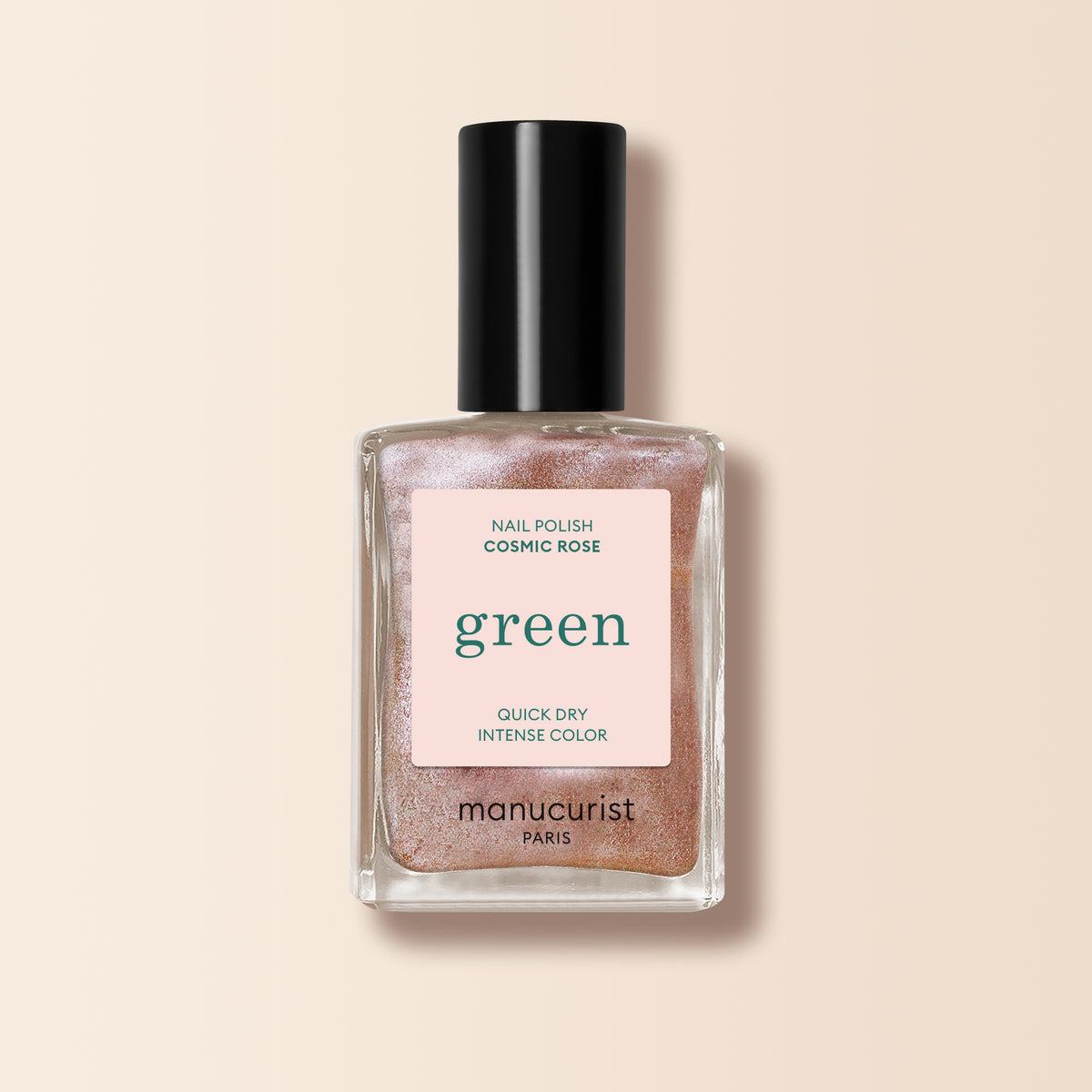 A bottle of Manucurist nail polish in the shade Cosmic Rose, featuring shimmery, iridescent pink color with a black cap and a pink label that reads "green" and states Quick Dry Intense Color.