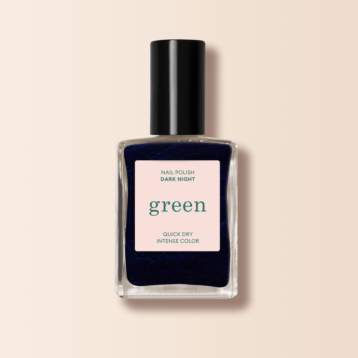 A square glass bottle of Manucurist Dark Night nail polish, midnight blue shade with a black cap. The label says Dark Night, Green range, Quick Dry Intense Color on a pale background.