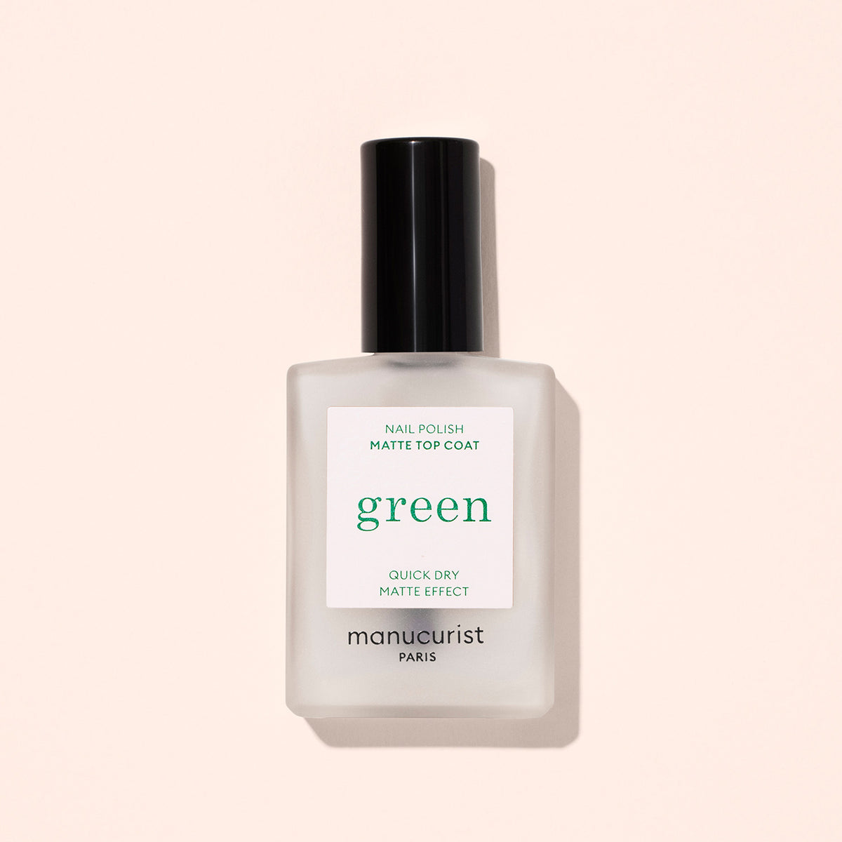 Un flacon en verre dépoli de Manucurist Matte Top Coat avec un bouchon noir, idéal pour une manucure à base de plantes, se détache sur un fond beige clair. L’étiquette indique "Effet mat séchage rapide.