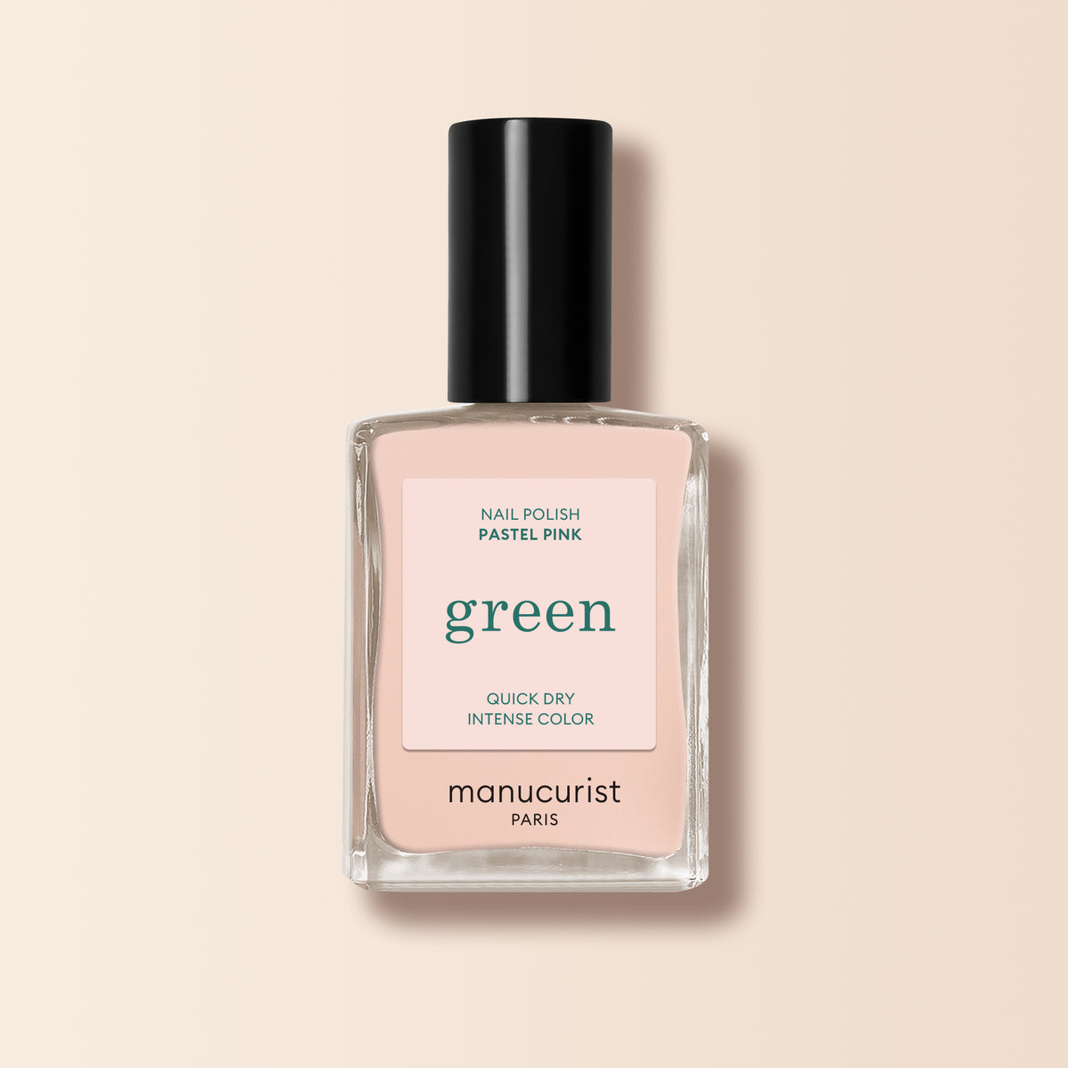 A bottle of Manucurist Pastel Pink nail polish from the Green™ range, with a black cap and quick-dry, intense color. The label showcases its Green™ credentials on a beige-toned background.