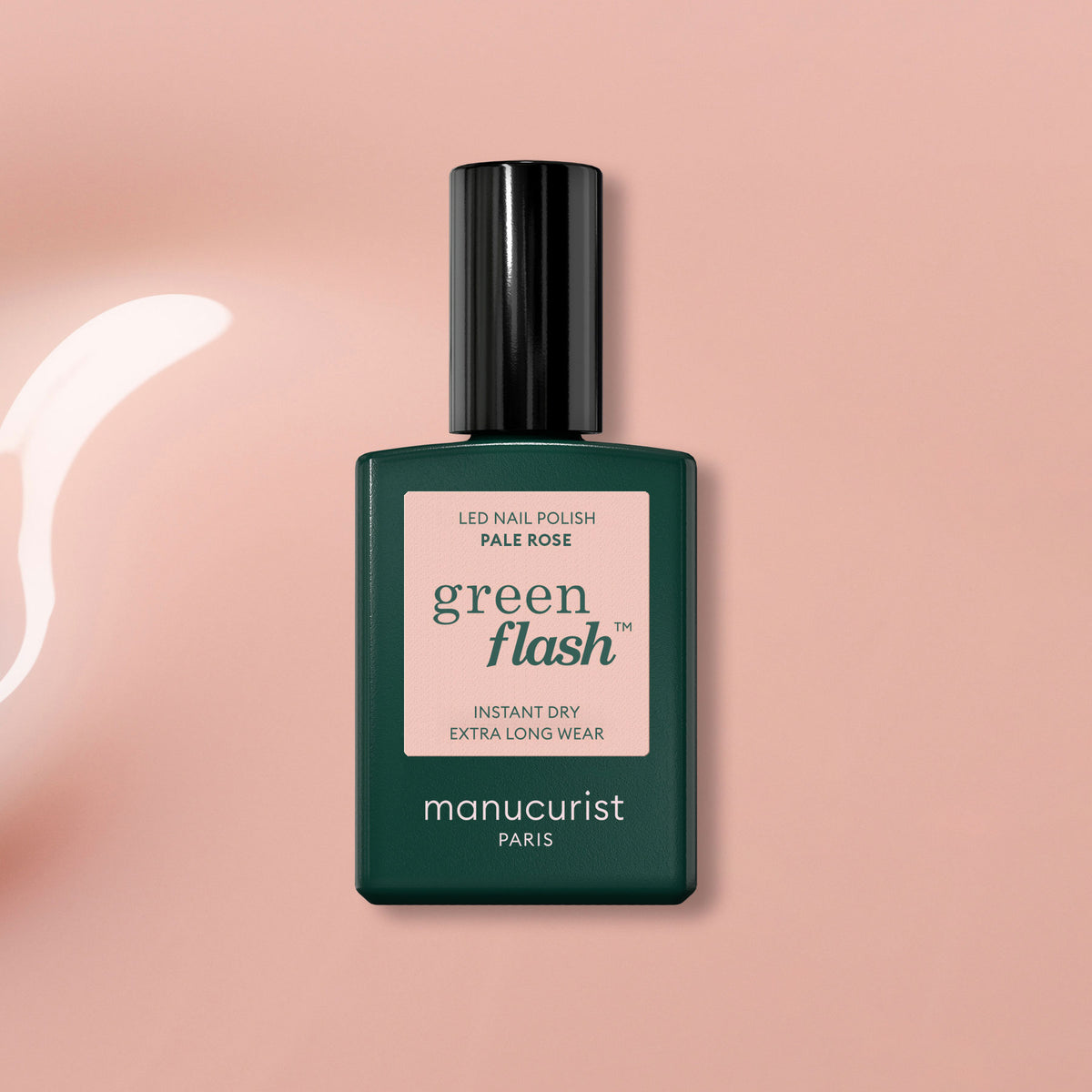 Un flacon de vernis gel Manucurist Pale Rose posé sur une surface rose clair brillante, à côté d&